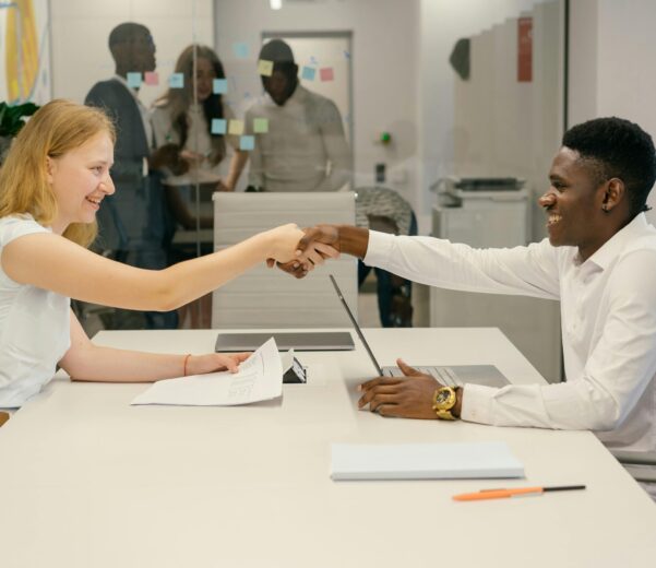 Free Business professionals completing a successful deal with a handshake in a modern office setting. Stock Photo